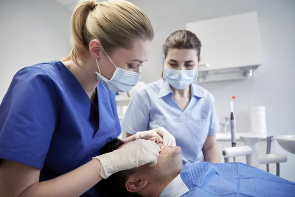Dentista femenino chequeando paciente oclusión dental —  Fotos de Stock