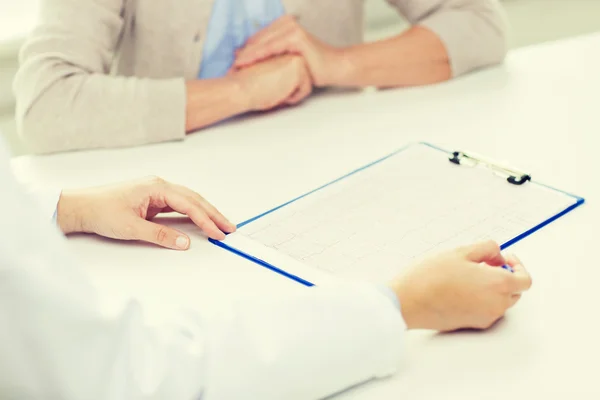 Close up of senior woman and doctor with clipboard — Stock Photo, Image