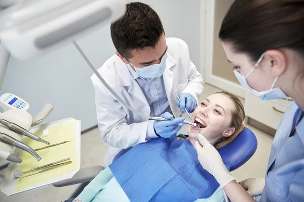 Male dentist treating female patient teeth — Stock Photo, Image