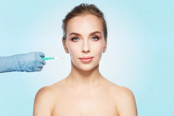 Kvinna ansikte och hand med spruta att göra injektion — Stockfoto