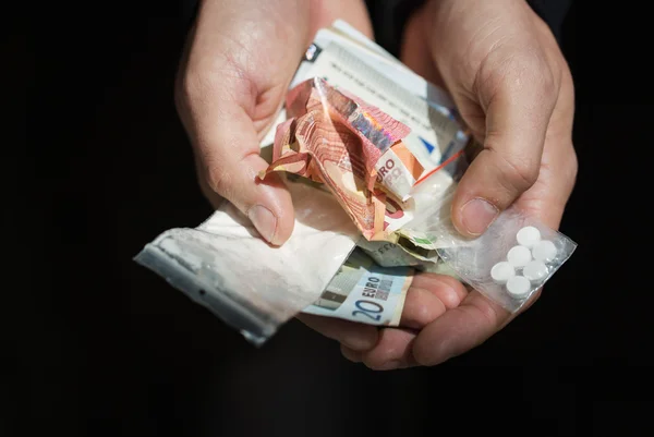 Close up of addict hands with drugs and money — Stock Photo, Image