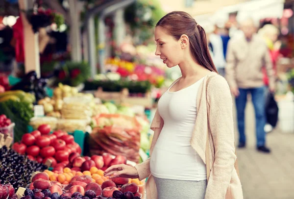 Mujer embarazada eligiendo comida en el mercado callejero — Foto de Stock