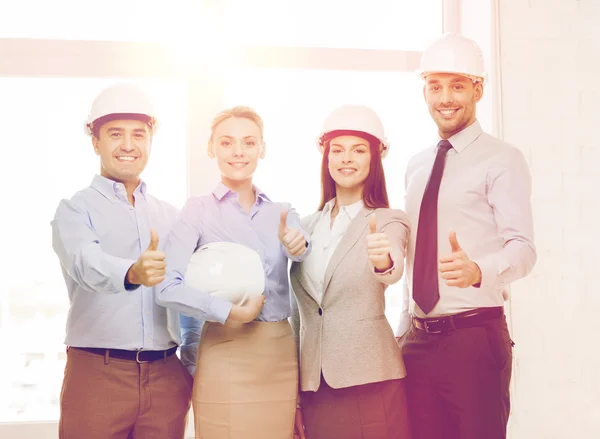 Feliz equipo de negocios en la oficina mostrando pulgares hacia arriba — Foto de Stock