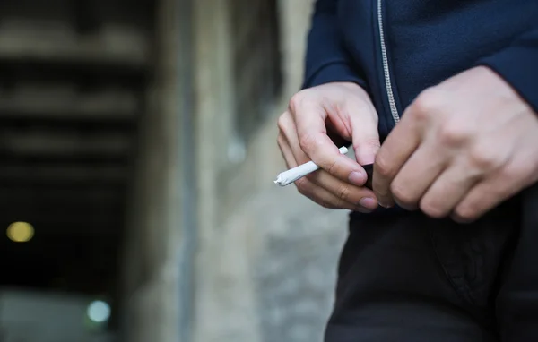 Perto de mãos viciadas com maconha conjunta — Fotografia de Stock