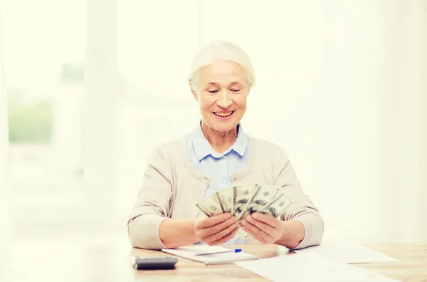 Seniorin mit Geld und Papieren zu Hause — Stockfoto