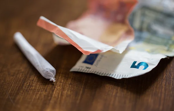 Close up of marijuana joint and money — Stock Photo, Image