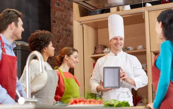 Gelukkige vrienden met tablet pc in keuken — Stockfoto