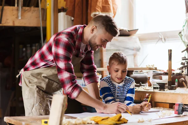 Lycklig far och son med blueprint på verkstad — Stockfoto