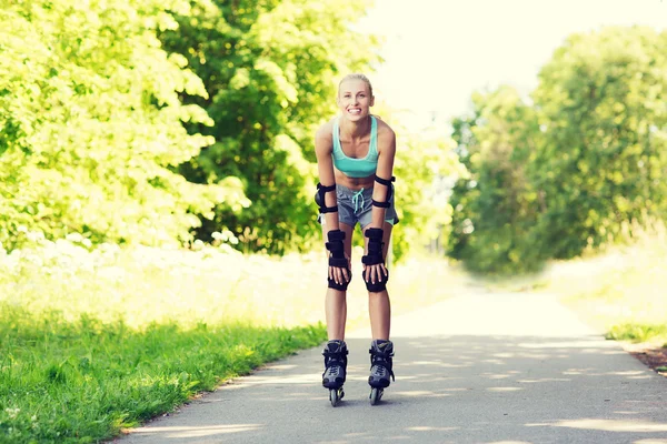 Glad ung kvinna i rullskridskor ridning utomhus — Stockfoto