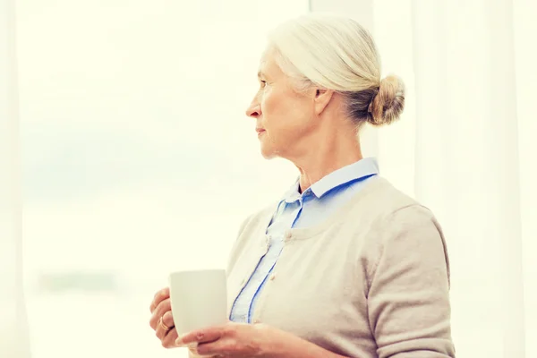 Einsame Seniorin mit einer Tasse Tee oder Kaffee — Stockfoto