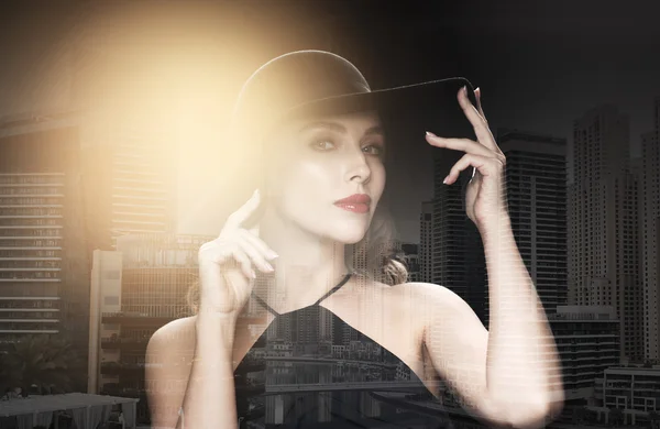 Bella donna in cappello nero su sfondo scuro — Foto Stock