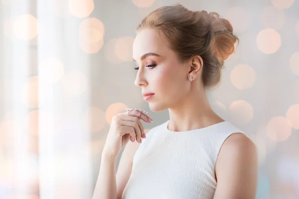 Lachende vrouw in witte jurk met diamanten juwelen — Stockfoto