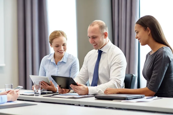 Souriants hommes d'affaires avec tablette PC dans le bureau Photo De Stock