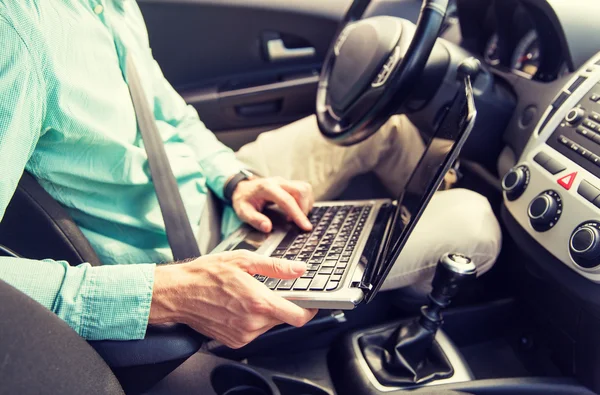 Primo piano di giovane uomo con computer portatile guida auto — Foto Stock