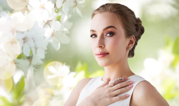 Mujer sonriente en vestido blanco con joyas de diamantes — Foto de Stock