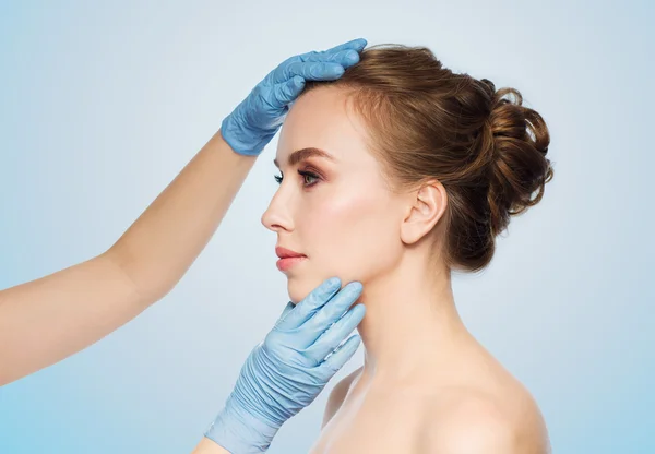 Megható a nő arca sebész vagy kozmetikus kezek — Stock Fotó