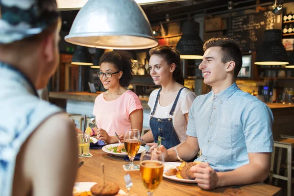 Happy přátelé, jídlo a pití na bar či hospodu — Stock fotografie