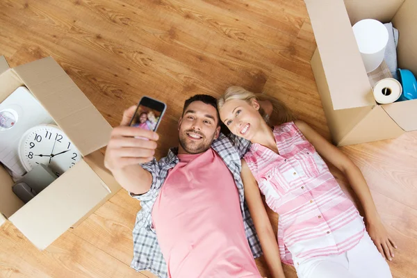 Couple taking selfie with smartphone on floor — 图库照片