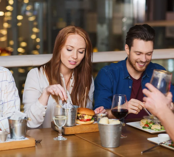 Man with smartphone and friends at restaurant — Stock Photo, Image