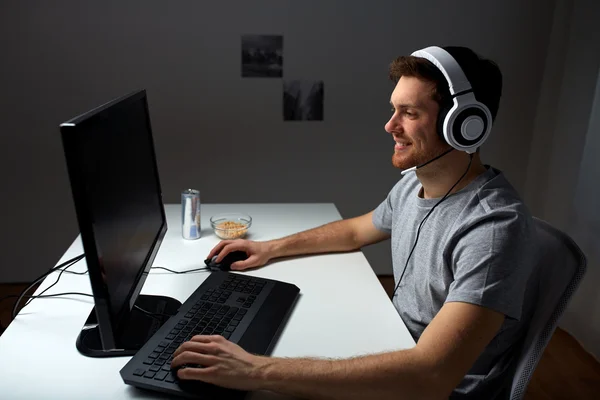 Uomo in cuffia giocare al videogioco per computer a casa — Foto Stock
