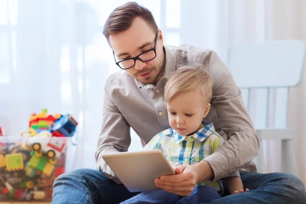 Pai e filho com tablet pc jogando em casa — Fotografia de Stock