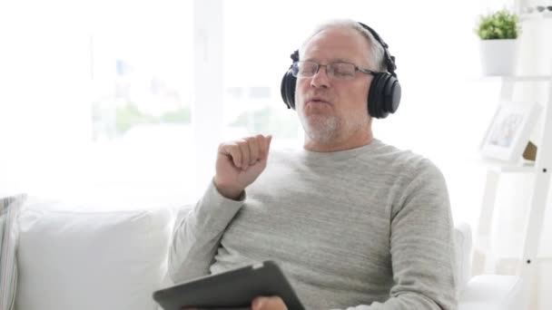 Senior homme avec tablette PC et écouteurs à la maison 14 — Video