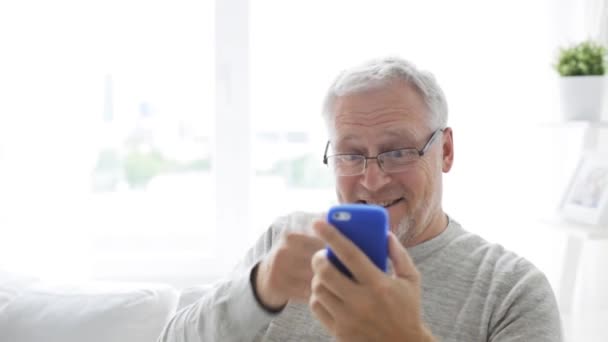 Старший мужчина с видеозвонком на смартфон дома 18 — стоковое видео