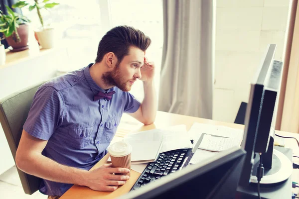 Creatieve mannelijke werknemer met computer drinken koffie — Stockfoto