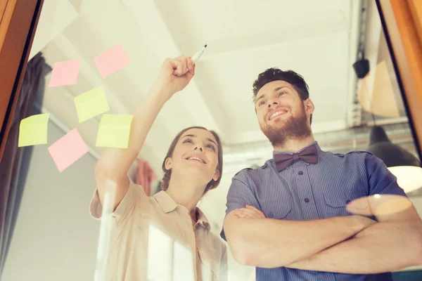 Feliz equipo creativo escribiendo en vidrio de oficina en blanco —  Fotos de Stock