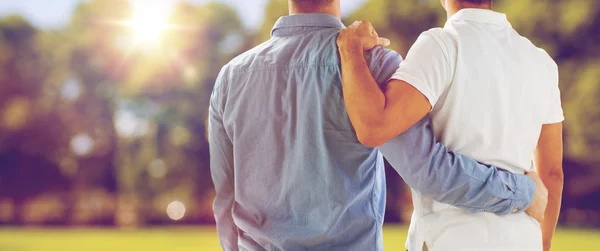 close up of happy male gay couple hugging