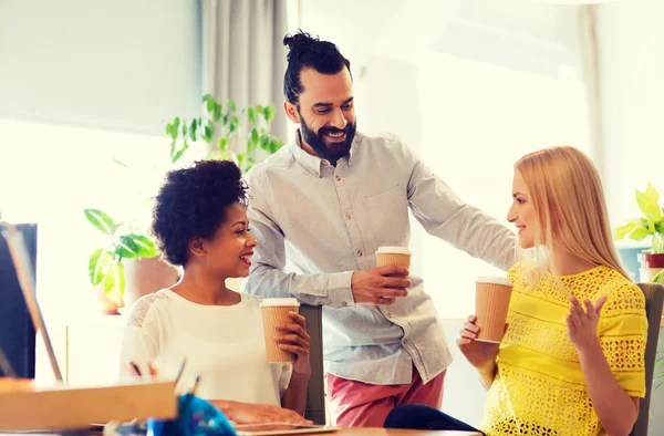 Equipe de negócios com xícaras de café conversando no escritório — Fotografia de Stock