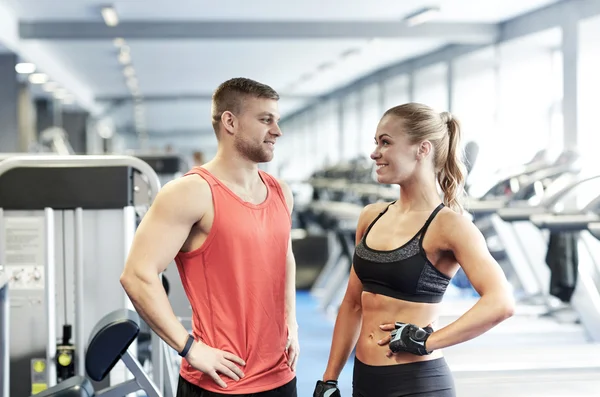 Glimlachende man en vrouw praten in de sportschool — Stockfoto