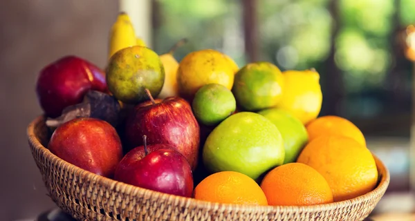 Cesta de frutas frescas maduras suculentas na cozinha — Fotografia de Stock