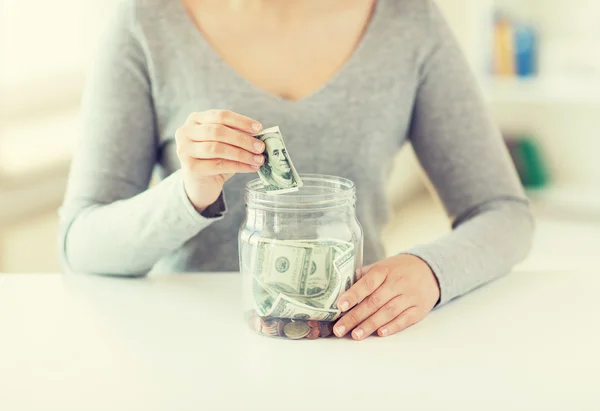 Close up de mãos de mulher e dinheiro dólar em jarra — Fotografia de Stock