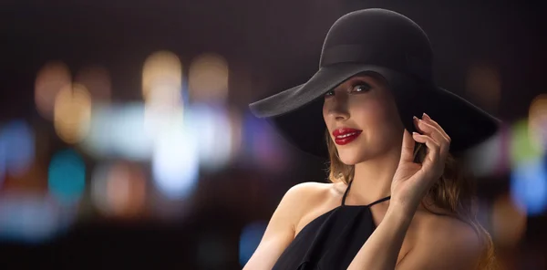 Hermosa mujer en sombrero negro sobre luces de noche —  Fotos de Stock