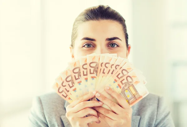 Kvinna gömmer sig hennes ansikte bakom euron pengar fan — Stockfoto