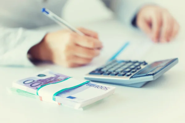 Close up of hands counting money with calculator — Stock Photo, Image