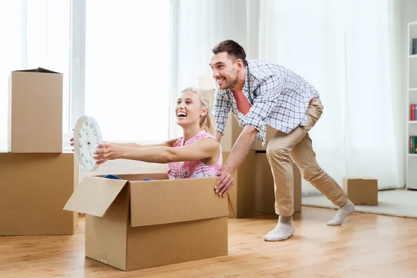 Pareja con cajas de cartón que se divierten en un nuevo hogar — Foto de Stock