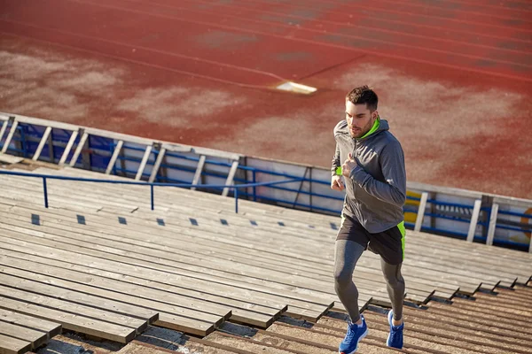 Young man running upstairs on stadium — Stock Photo, Image