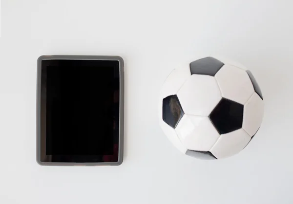 Закрыть глаза на футбол или футбольный мяч и планшетный компьютер — стоковое фото