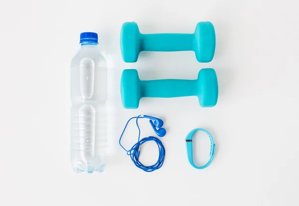 Halteres, rastreador de fitness, fones de ouvido e garrafa — Fotografia de Stock