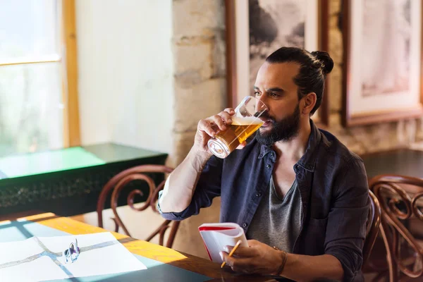 Mannen med notebook dricka öl på bar eller pub — Stockfoto