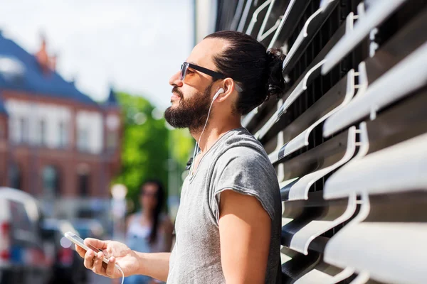 Hombre feliz con auriculares y smartphone en la ciudad —  Fotos de Stock