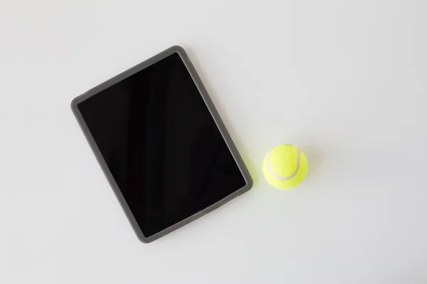 Close up of tennis ball and tablet pc over white — Stock Photo, Image