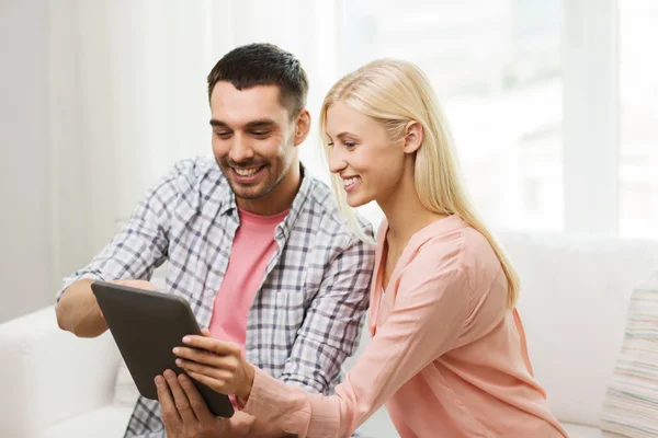 Sorridente coppia felice con tablet pc a casa — Foto Stock