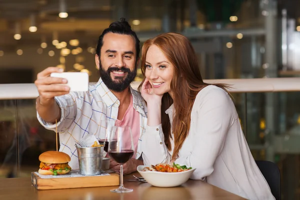 Pár selfie brát do smartphone v restauraci — Stock fotografie