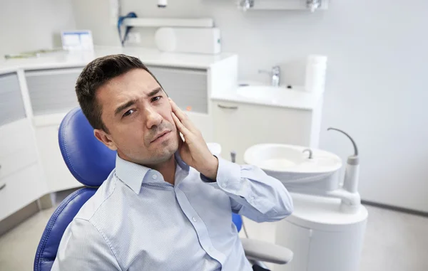 Mann hat Zahnschmerzen und sitzt auf Zahnarztstuhl — Stockfoto