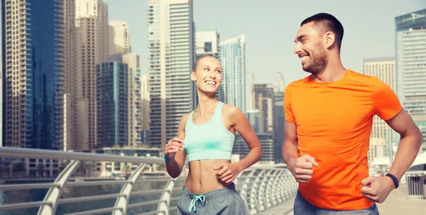 Couple running over dubai city street background — Stock Photo, Image