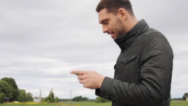 Man med smartphone promenader längs landsbygden väg 18 — Stockvideo