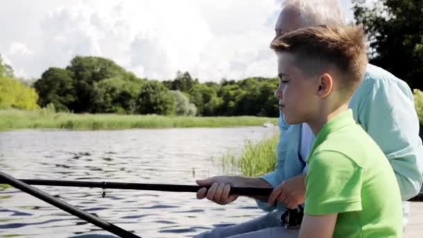 Grandfather and grandson fishing on river berth 10 — Stock Video